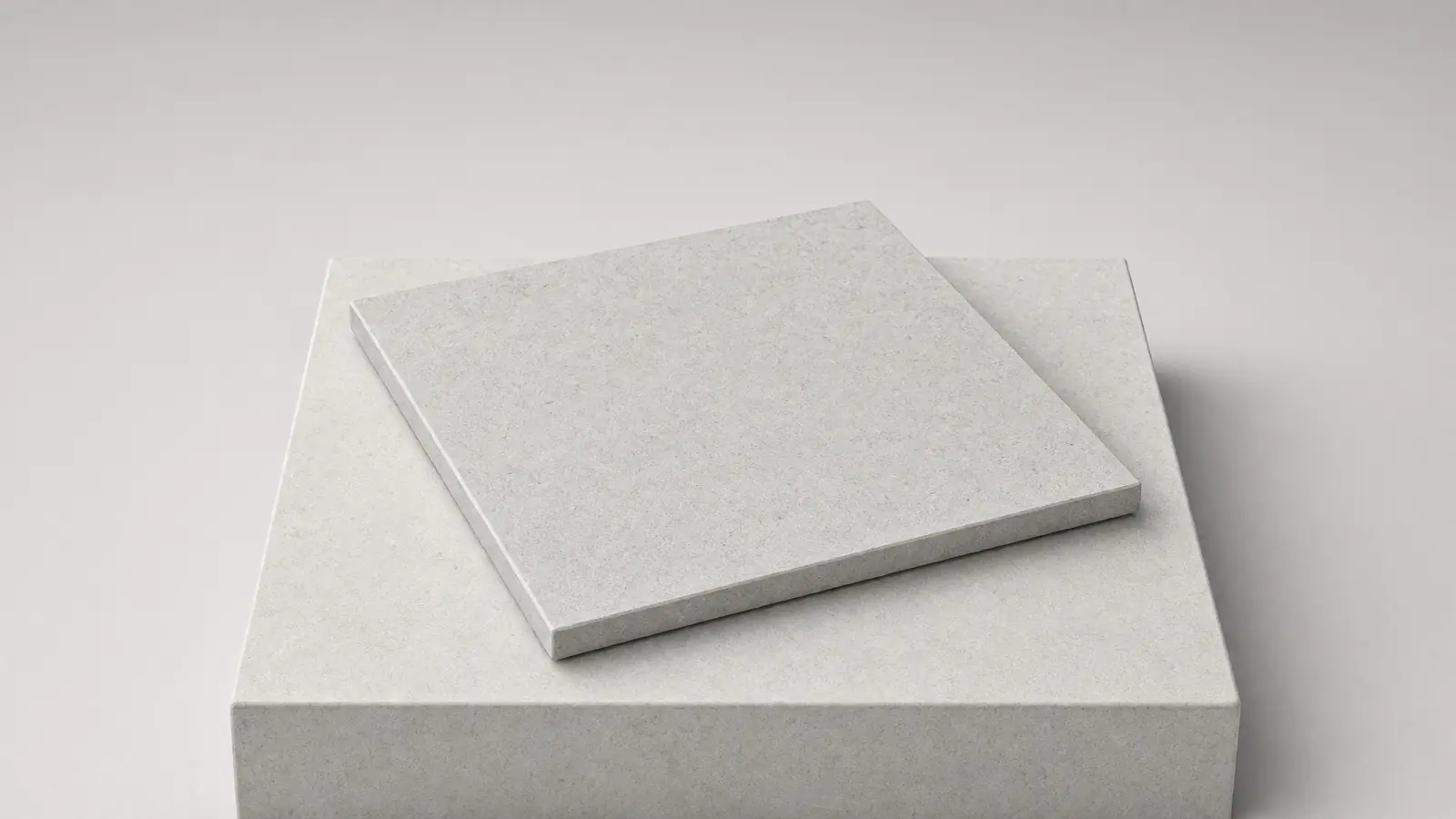 A pale grey porcelain paving tile on a pale stone plinth